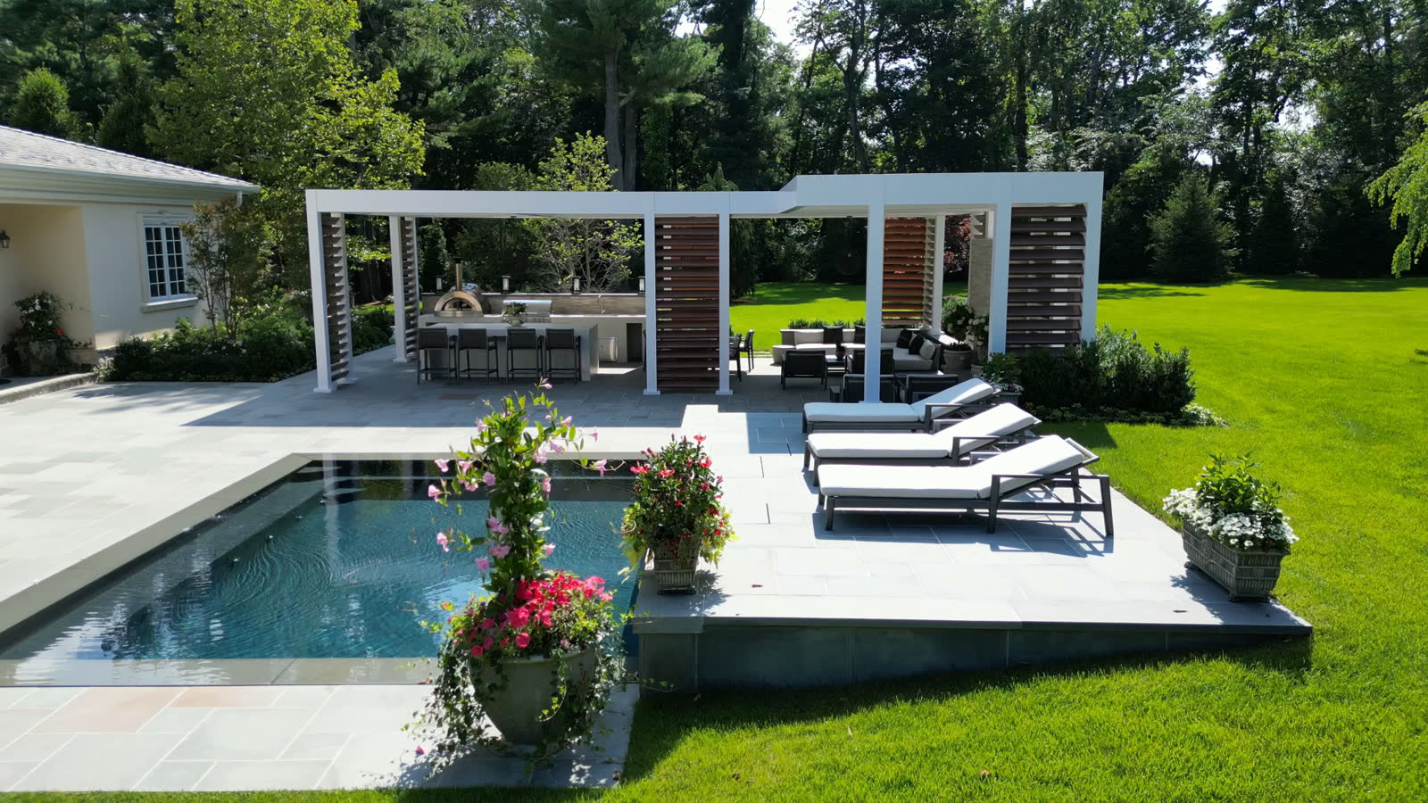 Completed pergola with pool, loungers, and landscaping