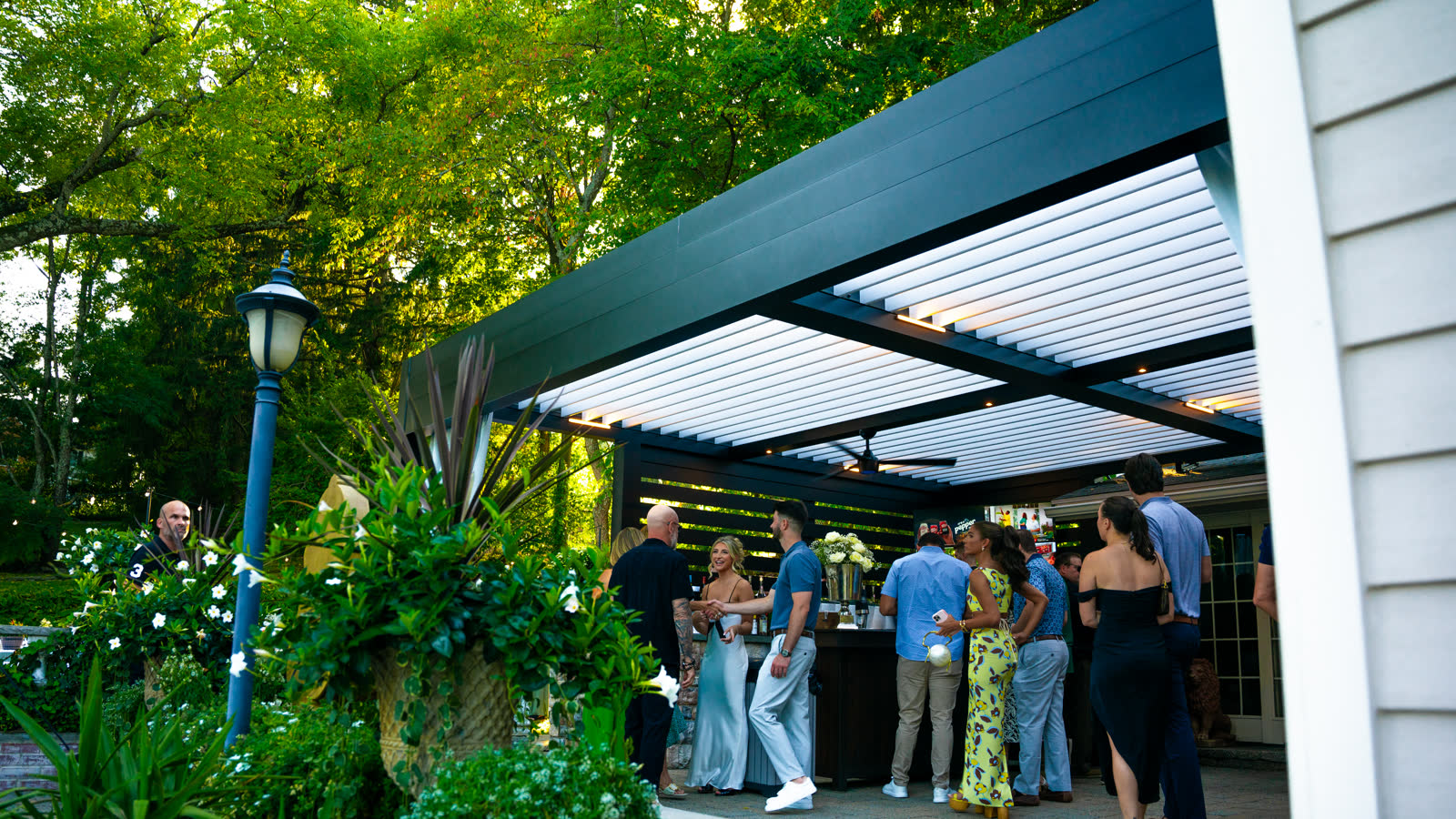 Guests enjoying outdoor space under louvered pergola