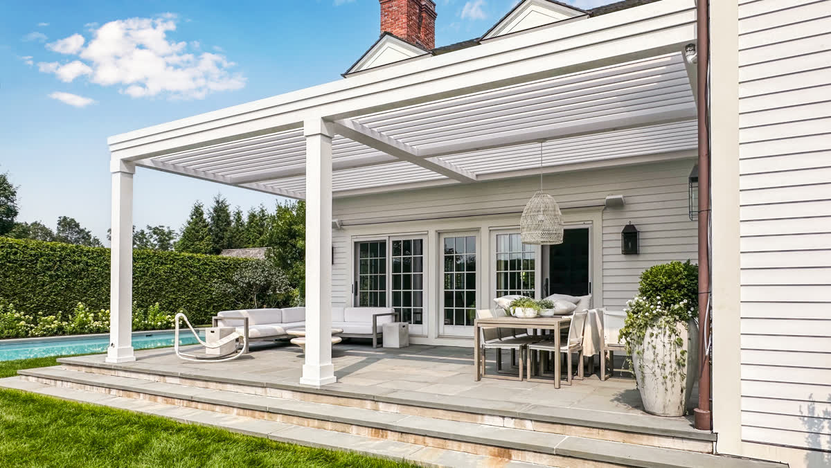 White transitional louvered pergola matching colonial home